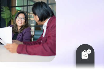 Two women discussing documents in a meeting room