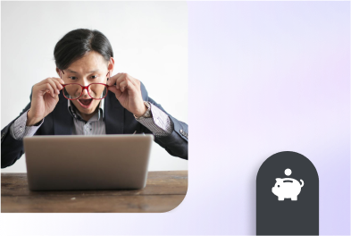 Man working on a laptop, adjusting his glasses and smiling